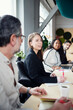 © Johnér - Female manager discussing strategies with team in meeting room at office