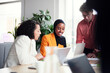 © Johnér - Smiling female entrepreneur explaining strategies to colleagues in office meeting