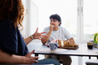 © Johnér - Man leaning on elbow and listening to her friend sitting at dining table