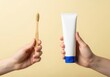 © Md - Hands holding a bamboo toothbrush and a tube of toothpaste on a beige background, promoting sustainable oral hygiene practices for a healthy smile
