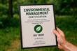 © Creative mind - Eco-friendly certificate being held, reflecting on the environmental preservation.