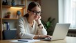 © Putra - Young Woman Studying Online with Laptop and Glasses