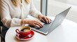 © Roushon - Woman working on laptop with coffee on table, showcasing productivity, remote work, and the blend of technology and caffeine for a productive day