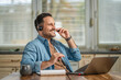 © Miljan Živković - Man smiling enjoying working from home with headset