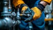 © Edi Purnomo - Worker Inspecting Industrial Pipes with Protective Gloves.