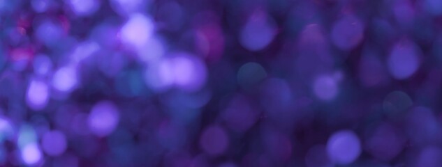 Indigo glitter bokeh background with violet glowing defocused lights for Christmas or New Year design backdrop
