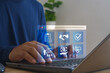 © MUNTHITA - Businessman using laptop with employee benefits digital interface icons for health insurance, finance, data management. Concept of online service, fintech technology, digital business communication.