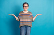 © deagreez - Smiling mature woman with short gray hair, wearing a patterned sweater, gesturing confidently against a solid blue background