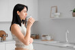 © Pixel-Shot - Beautiful pregnant woman drinking milk in kitchen