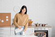 © Pixel-Shot - Beautiful young woman pouring milk into glass in kitchen