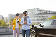 © sofiko14 - A couple wearing VR headsets while their electric vehicle charges, showcasing modern technology and sustainable transportation.