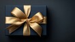 © Nasreen - Dark blue christmas gift box with gold satin ribbon on dark background, festive holiday present top view with copy space for seasonal celebration and decoration