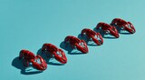 Six red crustaceans arranged diagonally against a cyan blue backdrop, creating a visually appealing scene