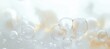 © dgete - Close-up view of transparent soap bubbles floating against a soft blurred light background with warm and cool tones