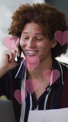 Wall Mural - Animation of red hearts over businessman using smartphone
