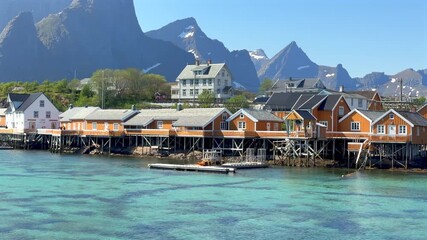 Wall Mural - Iconic Norwegian fishing village with mountains and turquoise water on a sunny day in Lofoten, Norway