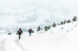 © Westend61 - Friends hiking in snowy Pyrenees mountains with trekking poles