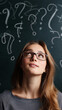 © Curioso.Photography - Young woman with glasses looking up surrounded by question marks on chalkboard background.