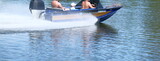 People are riding on a motorboat along the river; their faces are not visible. boat on the river