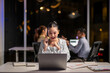 © Wasana - Businesswoman talking on phone and working late at office