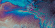 © Artem - Oil spill on asphalt creating a colorful abstract pattern reflecting light with iridescent rainbow colors, showing environmental issue and pollution concept