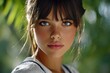 © MultiPixel Studio - Captivating close-up of a young girl with striking features surrounded by lush greenery during soft sunlight