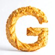 © Ninasarics - A golden-brown pastry shaped into the capital letter G, isolated on white
