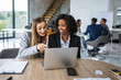 © Miljan Živković - Diverse businesswomen collaborating on laptop during office meeting