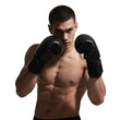 © Adobe Contributor - A young muscular man in boxing gloves is in a fighting stance, showcasing strength and readiness for combat.