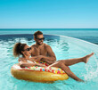 © New Africa - Couple having fun in swimming pool with infinity view on ocean