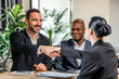 © wedmoments.stock - Business meeting with two men in suits shaking hands with a woman in a professional setting, surrounded by greenery, symbolizing partnership and collaboration in a corporate environment