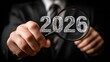© Alfanachmad - Businessman Inspecting the Year 2026 with a Magnifying Glass to Indicate Future Analysis
