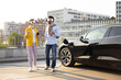 © sofiko14 - A couple wearing VR headsets chat near their electric vehicle while it charges.