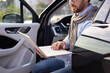 © sofiko14 - A businessman in glasses works on a laptop while sitting in a car, possibly during a commute or break.