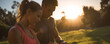 © Hathairat - Couple checking fitness watch during sunset outdoor run, athletic woman and man pause to view smartwatch data while standing in park at golden hour