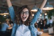 © Rifqi - Excited young woman with glasses raises her arms, celebrating achievement in office setting. Concept for business success, professional development and team collaboration
