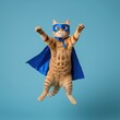 © PNG Stock  - A charming ginger tabby cat, adorned in a blue superhero cape and mask, leaps with paws raised against a bright blue backdrop, embodying playful feline heroism and joy