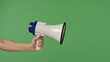 © kinomaster - A woman hand holding a megaphone on a green chroma key background. Shot for designs related to office, business, education, training, or social matters.