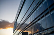 © yaqui_villegas - Low angle view of modern corporate glass tower reflecting warm sunset sky expressing transparency, growth, and economic optimism within contemporary urban architecture
