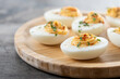 © chandlervid85 - Homemade hard Boiled Deviled Eggs garnished with herbs on wooden table