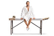 © Ljupco Smokovski - Man in a white bathrobe sitting on a massage table