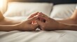 © detiyy - Two hands holding together on a bed