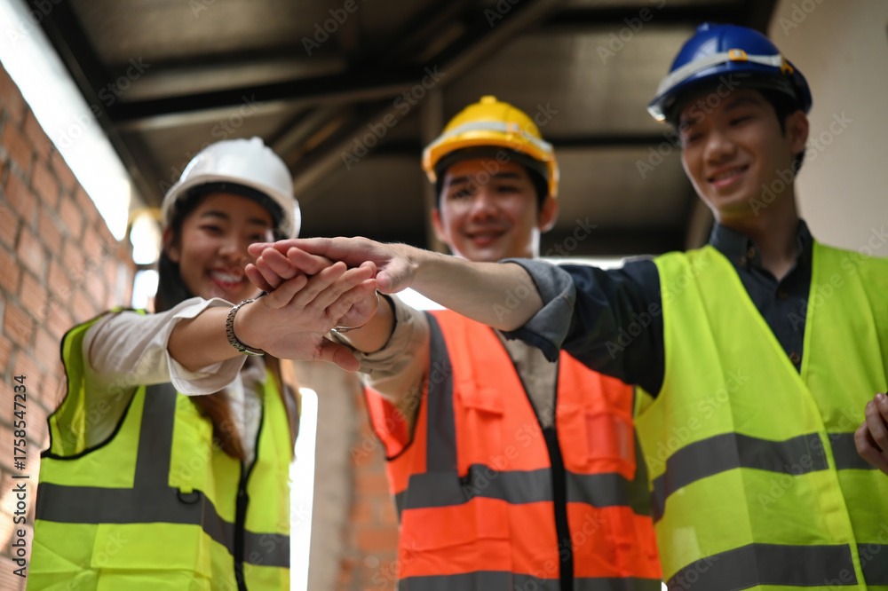 Construction professional team join hands in a teamwork gesture ...