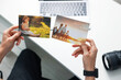© New Africa - Professional photographer working with photos at white table, above view
