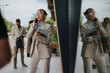 © qunica.com - Business professional speaking on phone, holding tablet, urban background with reflections.