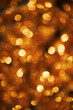 © DragonImages - Golden bokeh lights creating festive abstract background with warm glowing circles evoking Christmas holiday atmosphere suitable for seasonal designs and celebratory visuals