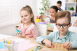 © New Africa - Cute children at wooden desks during lesson in elementary school