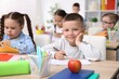 © New Africa - Portrait of cute little boy drawing at desk during art lesson in elementary school