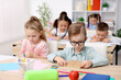 © New Africa - Cute children at wooden desks during lesson in elementary school