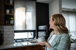 © Migma_Agency - Woman holding coffee cup relaxing in modern kitchen